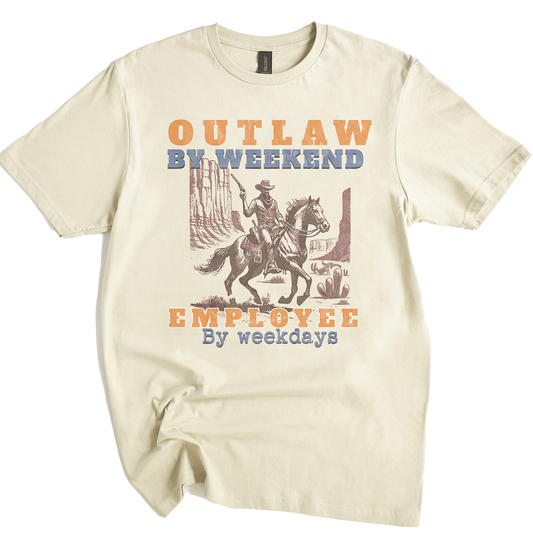 Beige t-shirt with a graphic of a cowboy on a horse and text 'Outlaw by weekend, Employee by weekdays' on a white background.