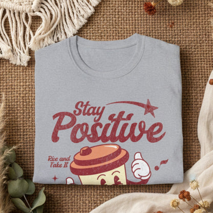 Folded gray t-shirt with 'Stay Positive' and coffee cup graphic on a white background