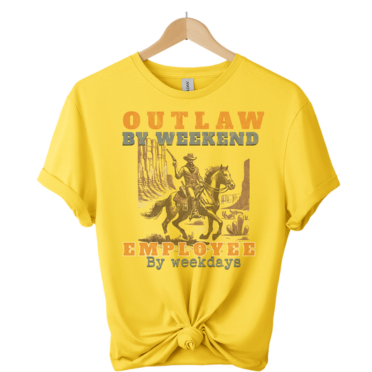 Yellow t-shirt with a graphic of a person on a horse and text, hanging on a wooden hanger.
