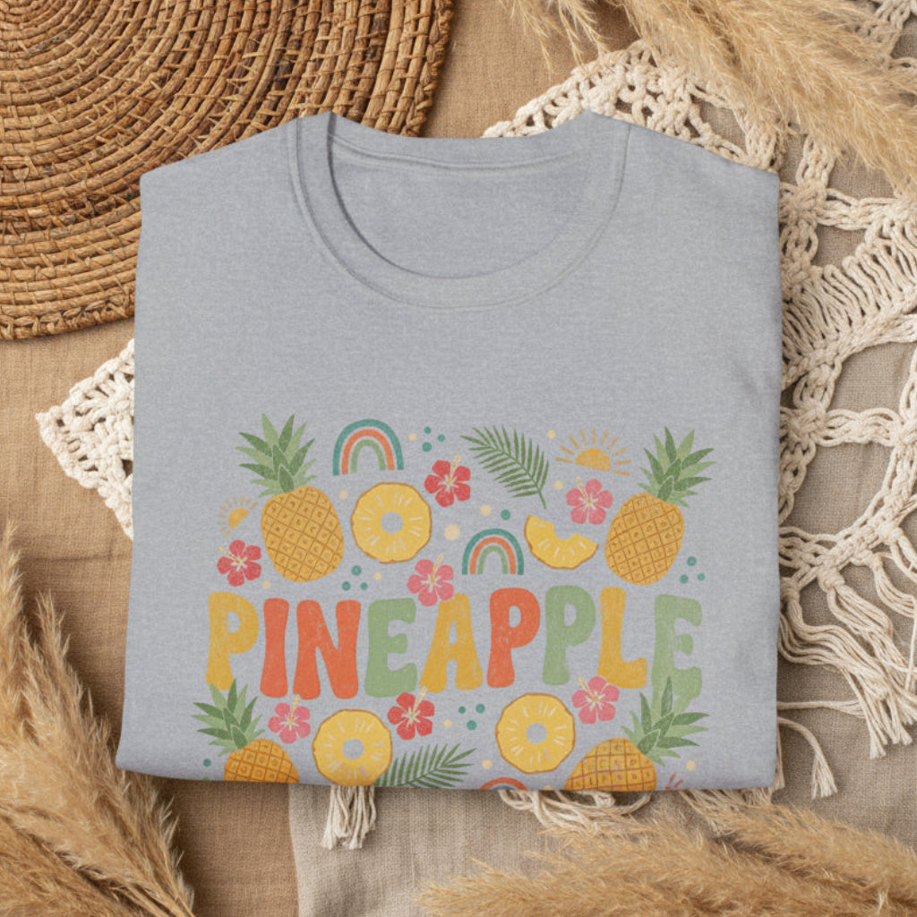 Folded gray t-shirt with colorful pineapple design on a white background