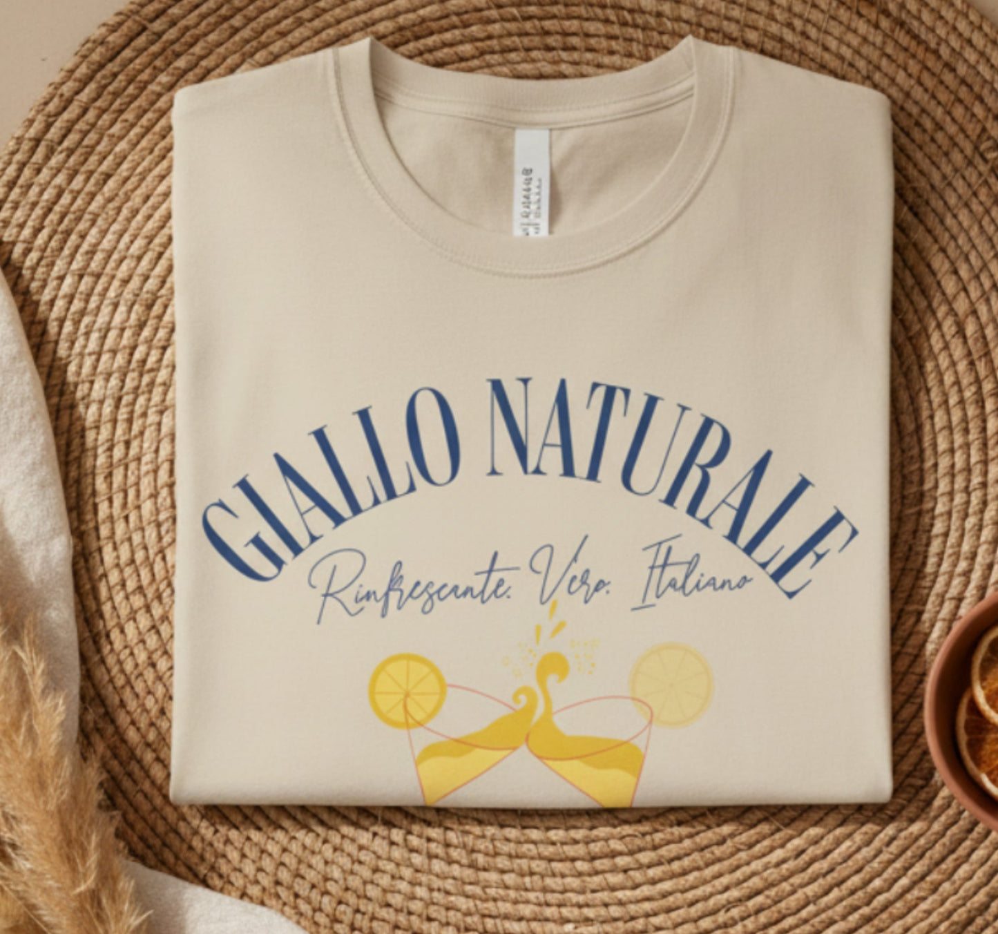 Folded sand t-shirt with blue and yellow text and graphics on a white background