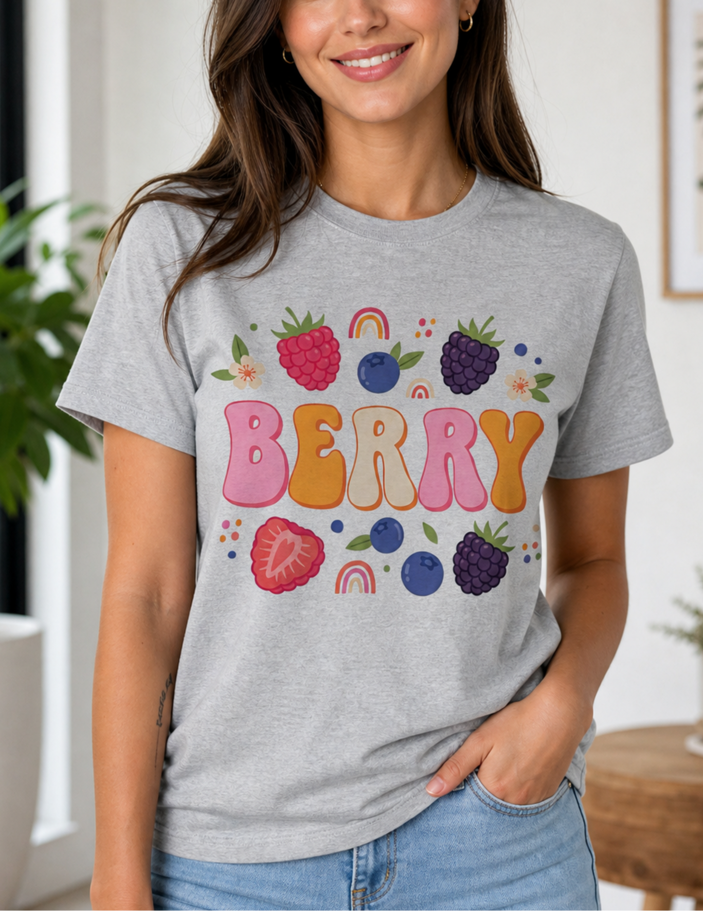Woman wearing a gray t-shirt with colorful berry design indoors