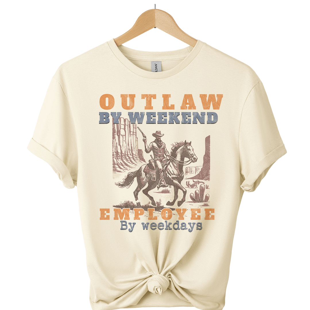 Beige t-shirt with a graphic of a cowboy on a horse and text 'Outlaw by weekend, Employee by weekdays' on a white background.