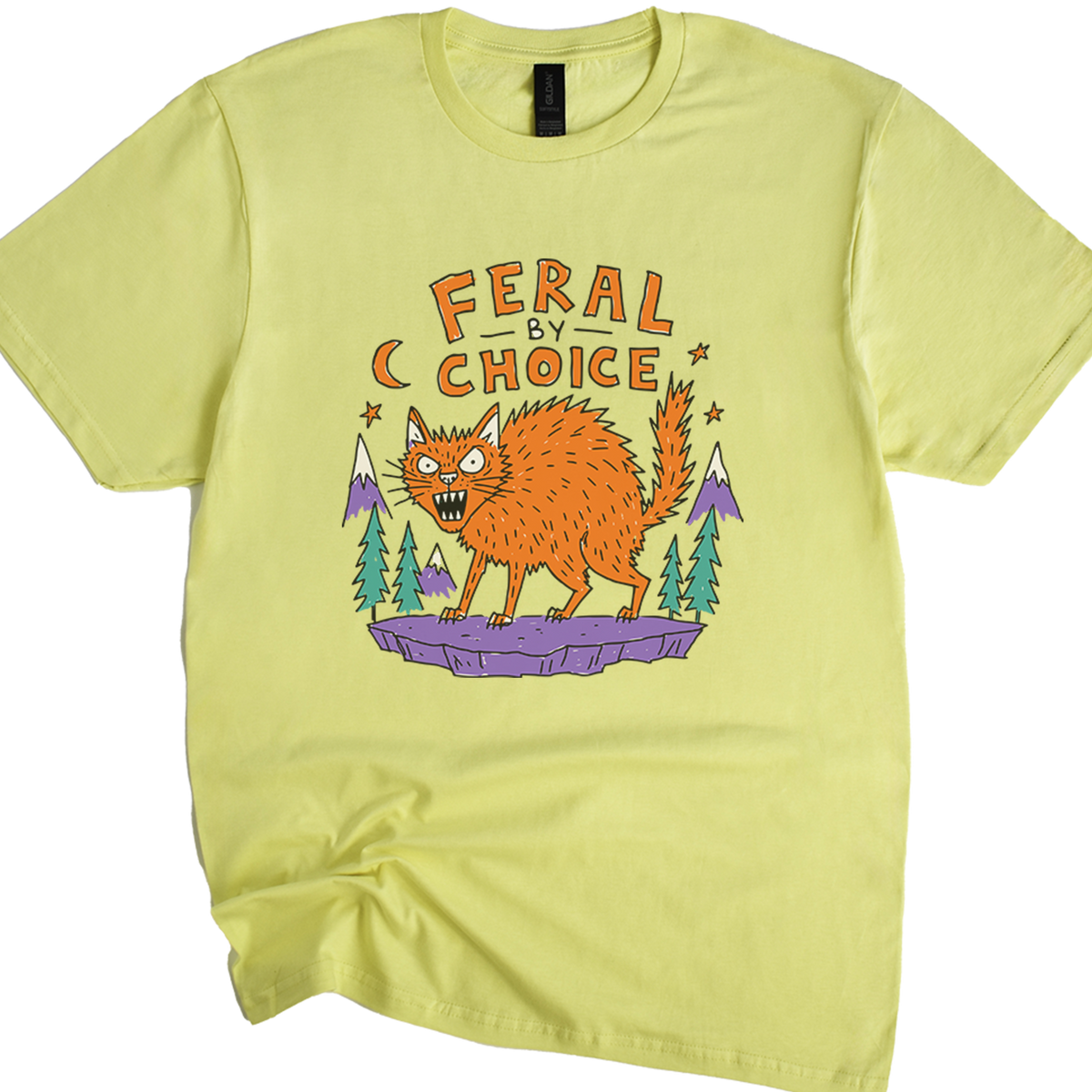 A cornsilk crewneck t-shirt featuring a cartoon graphic of an orange wild cat standing on a purple rock with pine trees and the text 'FERAL BY CHOICE'.neilikha