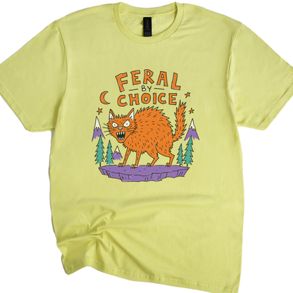 A cornsilk crewneck t-shirt featuring a cartoon graphic of an orange wild cat standing on a purple rock with pine trees and the text 'FERAL BY CHOICE'.neilikha