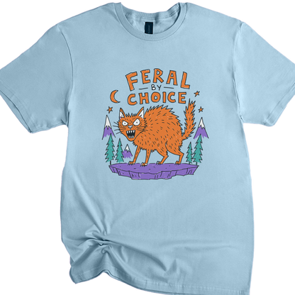 A light blue crewneck ringspun softstyle t-shirt featuring a cartoon graphic of an orange wild cat standing on a purple rock with pine trees and mountains, under the text 'FERAL BY CHOICE'.neilikha