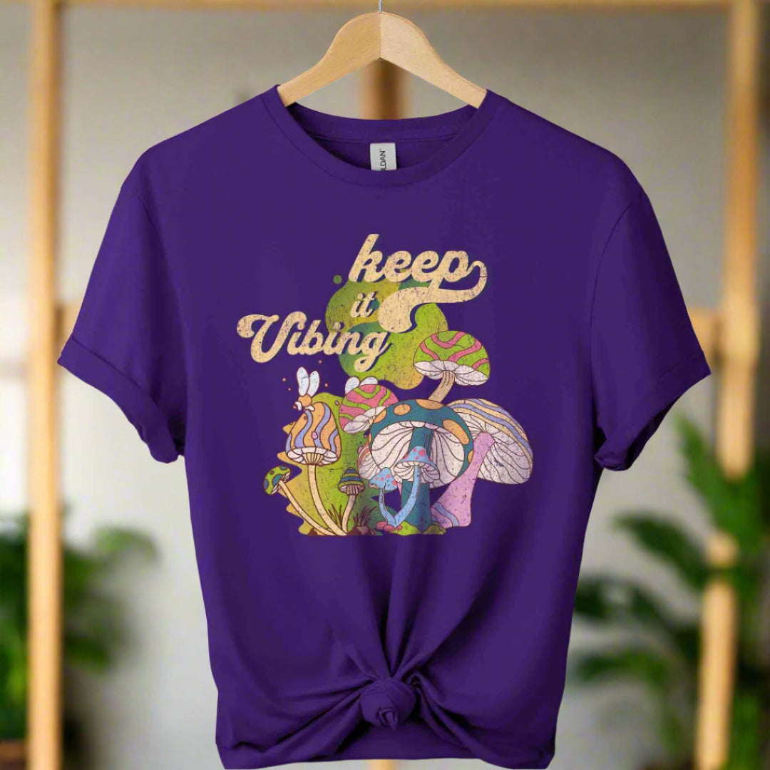 T-shirt color purple ,unisex with front design mushroom graphics and keep vibing typography ,retro tees 