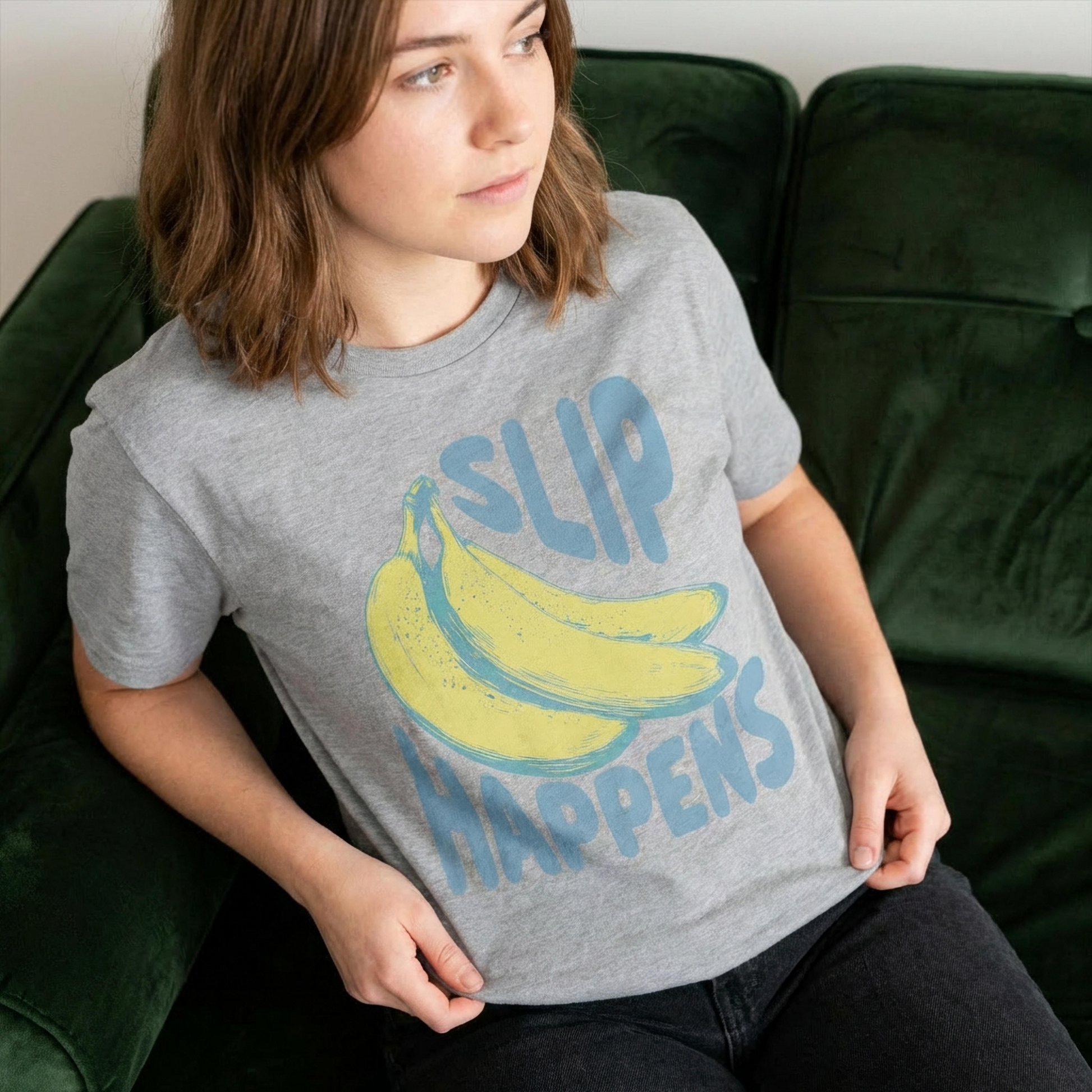 Person wearing a sportsgray t-shirt with a banana graphic and text sitting on a green couch.