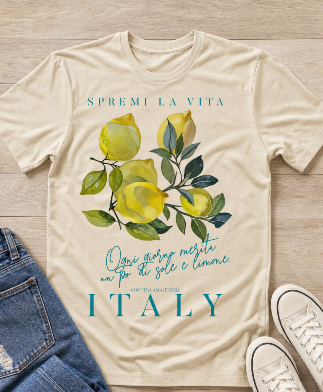 flat lay sand color t-shirt with a watercolor Mediterranean lemon graphic and teal Italian text reading Spremi La Vita Italy