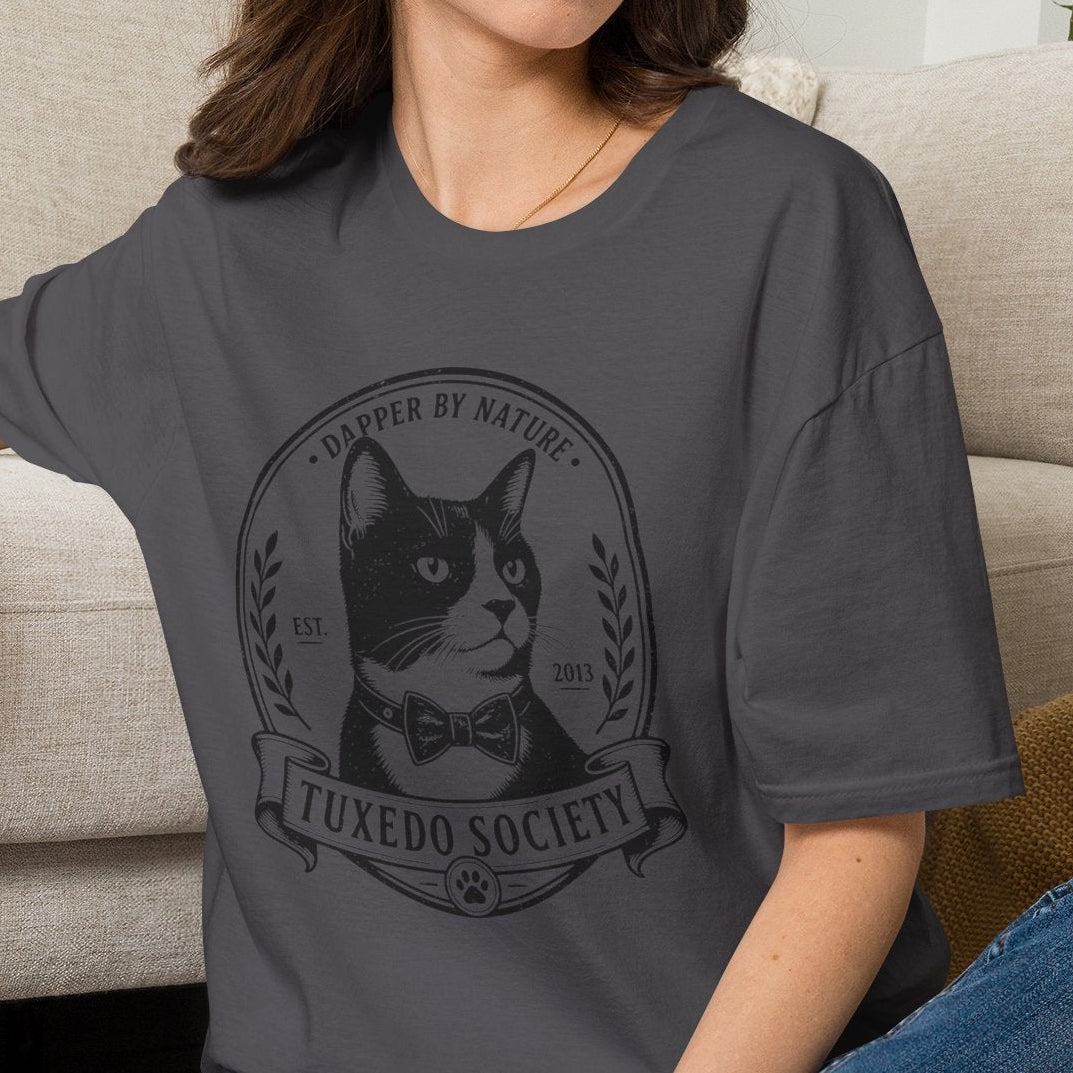 Women  wearing acharcoal  t-shirt with a graphic of a tuxedo cat society in a living room.