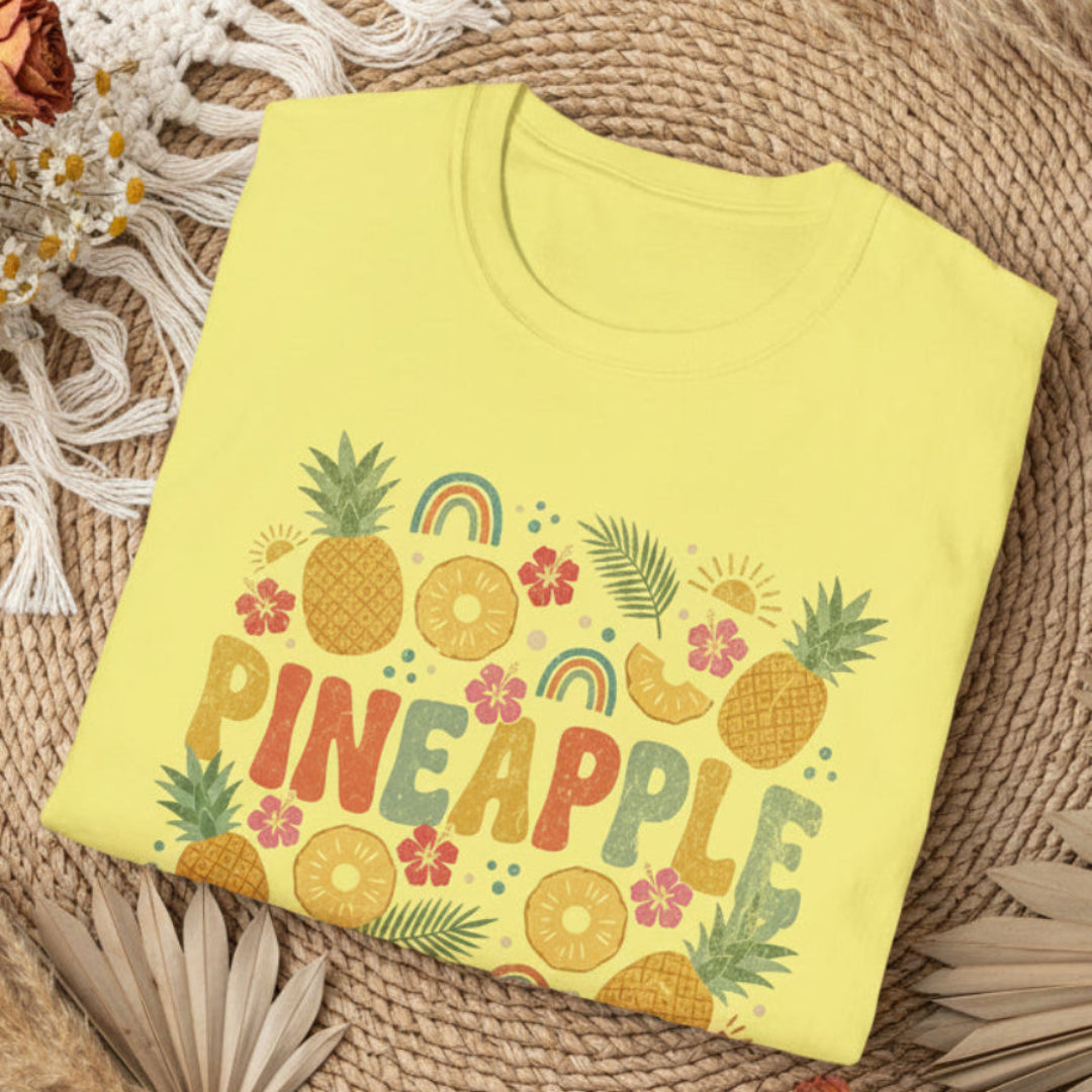 folded cornsilk t-shirt with pineapple graphics and text on a bohobackground