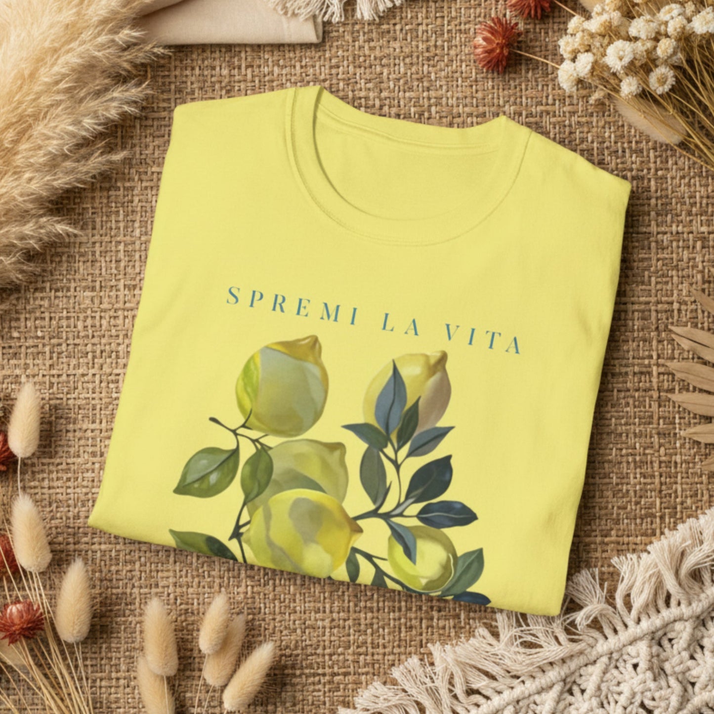 folded corn silk t-shirt with a watercolor Mediterranean lemon graphic and teal Italian text reading Spremi La Vita Italy
