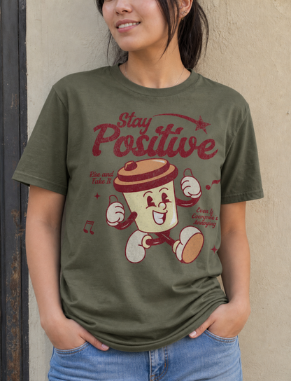 Person wearing a green t-shirt with a cartoon character and 'Stay Positive' text.